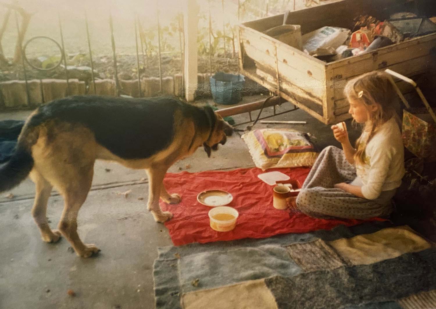 Young Zoe having a tea party with Dena the dog